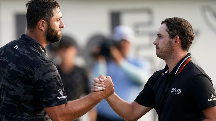 Jon Rahm of Spain, left, shakes hands with Patrick Cantlay on the 18th green during the third round of the Tour Championship golf tournament Saturday, Sept. 4, 2021, at East Lake Golf Club in Atlanta. (AP Photo/Brynn Anderson)