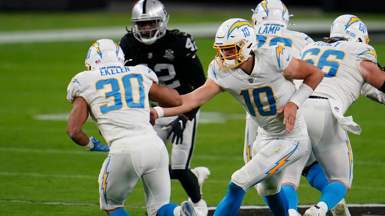 Los Angeles Chargers quarterback Justin Herbert hands off to running back Austin Ekeler