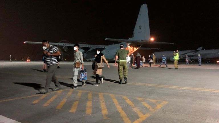 In this photo provided by the Australian Defence Force, evacuees from Afghanistan disembark a Royal Australian Air Force C-130J Hercules after arriving at Australia's main base in the Middle East region, Wednesday, Aug. 18, 2021, according to Australian defense. Australia plans to evacuate 130 Australians and their families plus an undisclosed number Afghans who have worked for Australian soldiers and diplomats in roles such as interpreters. (Australian Defence Force via AP)