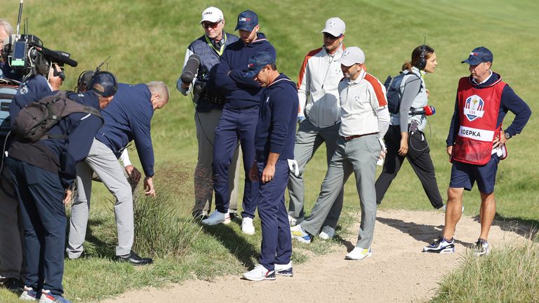 A rules lawyer inspects the lie of a ball for Daniel Berger of team United States and Brooks Koepka of team United States on the 15th hole during Saturday Morning Foursome Matches of the 43rd Ryder Cup at Whistling Straits on September 25, 2021 in Kohler, Wisconsin.