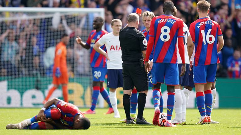 Referee Jon Moss sends off Japhet Tanganga for a challenge on Jordan Ayew