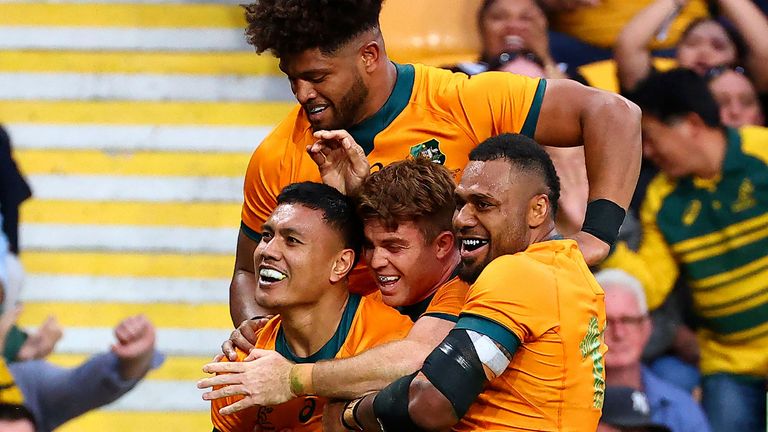 Australia's Len Ikitau (L) celebrates a try with team-mates