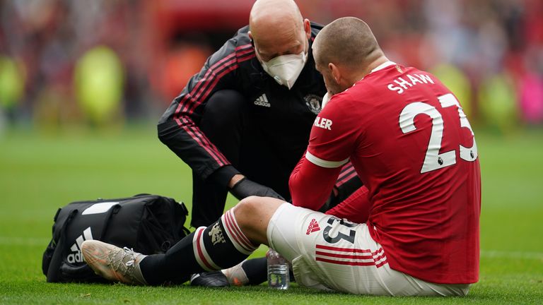 Luke Shaw receives medical treatment before leaving the field (AP)