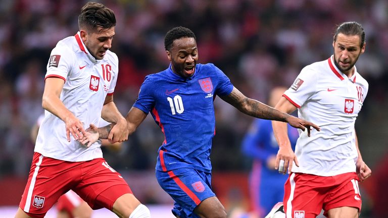 Raheem Sterling of England is tackled by Grzegorz Krychowiak and Jakub Moder of Poland