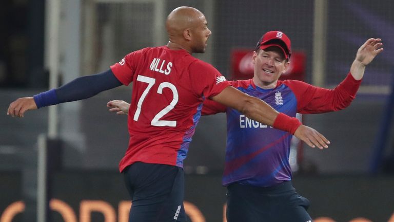 ngland's Tymal Mills, left celebrates with England's captain Eoin Morgan, after taking the wicket of West Indies' Chris Gayle caught by England's Dawid Malan during the Cricket T20 World Cup match between England and the West Indies at the Dubai International Cricket Stadium, in Dubai,
