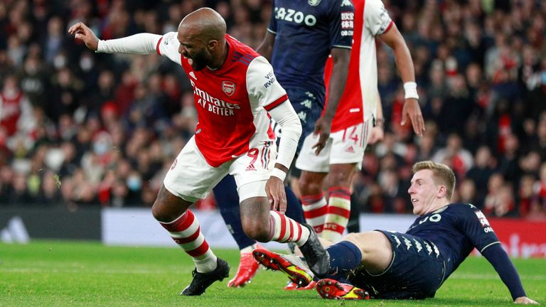 Arsenal's Alexandre Lacazette, center, duels for the ball with Aston Villa's Matt Targett, right, during the English Premier League soccer match between Arsenal and Aston Villa at the Emirates stadium in London, Friday, Oct. 22, 2021. (AP Photo/Ian Walton)