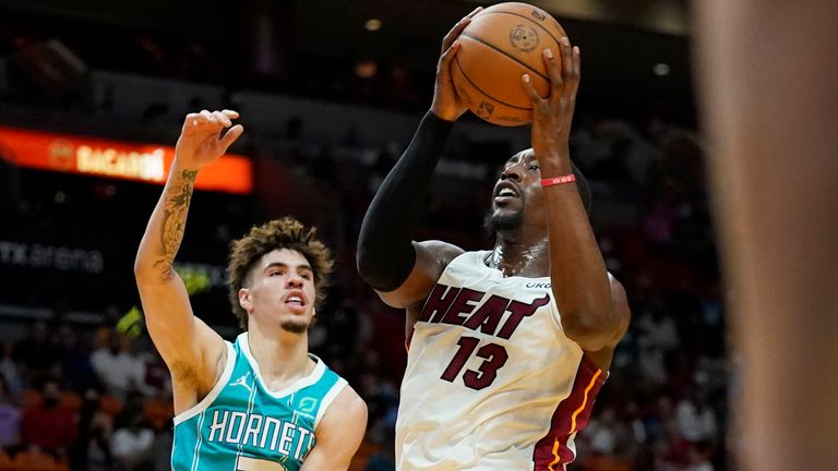 Miami Heat center Bam Adebayo (13) goes to the basket as Charlotte Hornets guard LaMelo Ball defends during the first half of a preseason NBA basketball game, Monday, Oct. 11, 2021, in Miami.