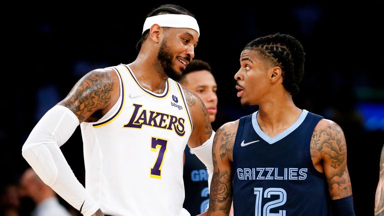 Los Angeles Lakers forward Carmelo Anthony (7) confers with Memphis Grizzlies guard Ja Morant (12) during the second half of Sunday night's game