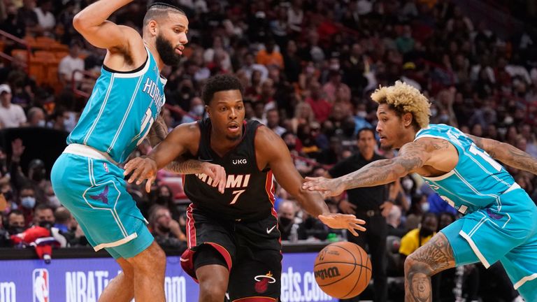 Miami Heat goalkeeper Kyle Lowery (7) dribbles Charlotte Hornets forward Cody Martin (11) and goalkeeper Kelly Uber Jr. (12) during the second half of an NBA basketball game, Friday, Oct. 29, 2021, in Miami.  (AP Photo/Marta Lavandier)