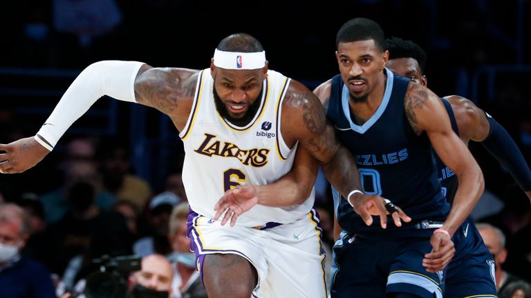 Los Angeles Lakers forward LeBron James (6) and Memphis Grizzlies guard De&#39;Anthony Melton (0) chase the ball during the second half of an NBA basketball game in Los Angeles, Sunday, Oct. 24, 2021. The Lakers won 121-118.