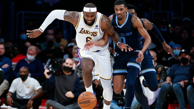 Los Angeles Lakers forward LeBron James (6) and Memphis Grizzlies guard De&#39;Anthony Melton (0) chase the ball during the second half of an NBA basketball game in Los Angeles, Sunday, Oct. 24, 2021. The Lakers won 121-118. (AP Photo/Ringo H.W. Chiu)