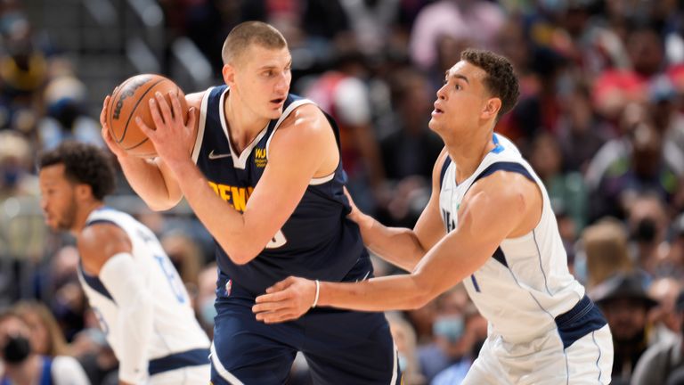 Denver Nuggets quarterback Nikola Jokic, left, looks to pass the ball as Dwight Powell defends the Dallas Mavericks in the first half of an NBA basketball game Friday, Oct. 29, 2021, in Denver.  (AP Photo/David Zalubowski)
