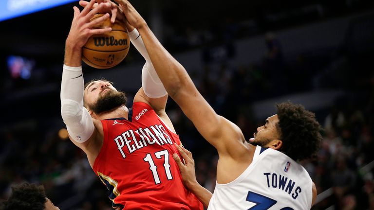 Minnesota Timberwolves center Karl-Anthony Towns (32) and New Orleans Pelicans center Jonas Valanciunas (17) rebound in the first half of an NBA basketball game, Monday, Oct. 25, 2021, in Minneapolis. 