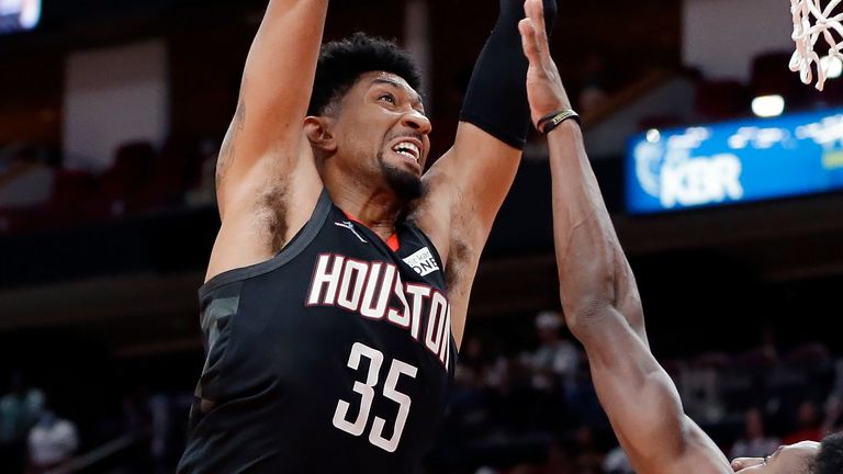 Houston Rockets center Christian Wood (35) dunks over Boston Celtics forward Aaron Nesmith, right, as guard Marcus Smart (36) looks on during the first half of an NBA basketball game Sunday, Oct. 24, 2021, in Houston. 