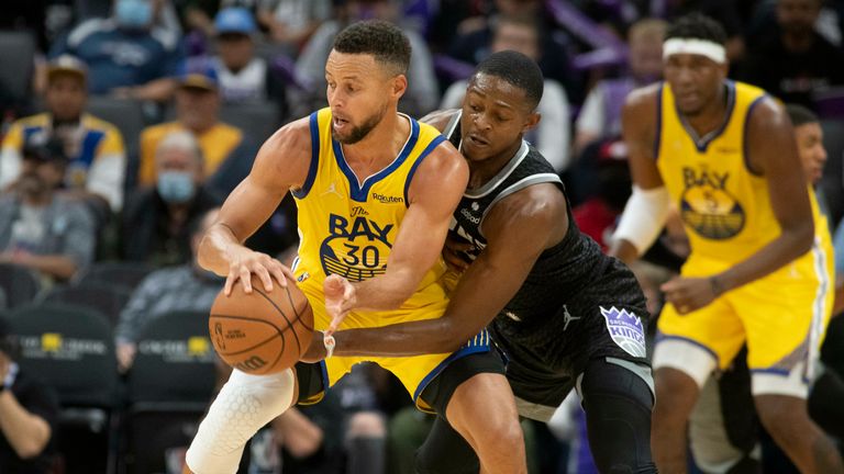 Il difensore dei Sacramento Kings D'Aaron Fox ha sconfitto il difensore dei Golden State Warriors Stephen Curry (30) durante la seconda metà del torneo di basket NBA a Sacramento, in California, domenica 24 ottobre 2021. I Warriors hanno vinto 119-107.