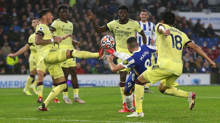 Ben White attempts to block a shot from Neal Maupay