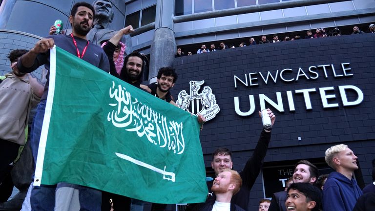 Newcastle fans celebrate after a Saudi-led consortium complete their takeover of the club