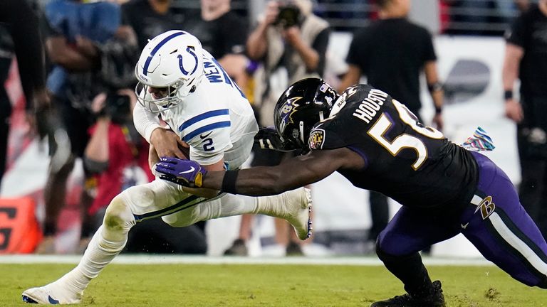 Indianapolis Colts quarterback Carson Wentz (2) is hit by Baltimore Ravens outside linebacker Justin Houston (50) during the second half of an NFL football game Monday, Oct. 11, 2021, in Baltimore.