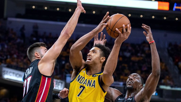 Indiana Pacers guard Malcolm Brogdon drives to the basket as Miami Heat guard Max Strus and center Bam Adebayo defend