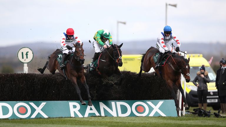 Protektorat (red cap) jumps the last at Aintree alongside Phoenix Way and Hitman