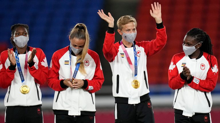 Canada's Quinn, second right, waves during the medal ceremony after beating Sweden in the women's final soccer match at the 2020 Summer Olympics, Saturday, Aug. 7, 2021, in Yokohama, Japan. (AP Photo/Andre Penner)