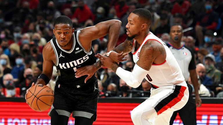 Sacramento Kings guard De&#39;Aaron Fox, left, tries to get past Portland Trail Blazers guard Damian Lillard during the first half of an NBA basketball game in Portland, Ore., Wednesday, Oct. 20, 2021. (AP Photo/Steve Dykes)