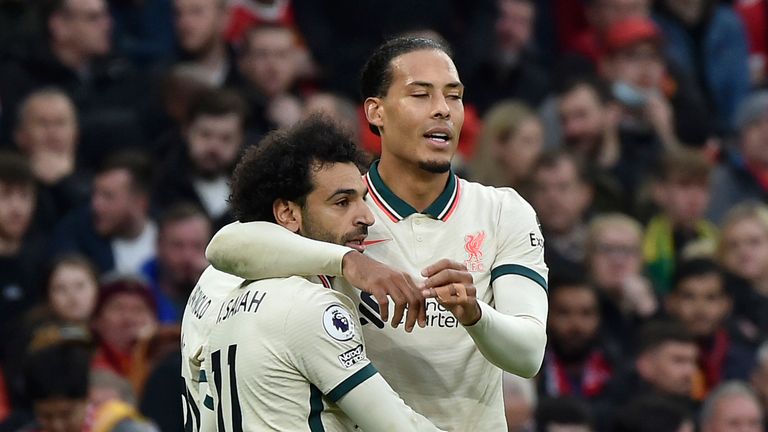 Liverpool's Mohamed Salah celebrates with Virgil van Dijk, right, after scoring his side's third goal during the English Premier League soccer match between Manchester United and Liverpool at Old Trafford in Manchester, England, Sunday, Oct. 24, 2021.
