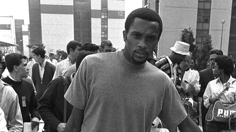 Tommie Smith carries suitcase as he leaves the Olympic Village in Mexico City on Wednesday, October 18, 1968 following his suspension from the American track and field team for making a black power demonstration on the victory stand Behind him to the right, wearing white cap and Mexican jacket, is John Carlos, who was suspended with him. 