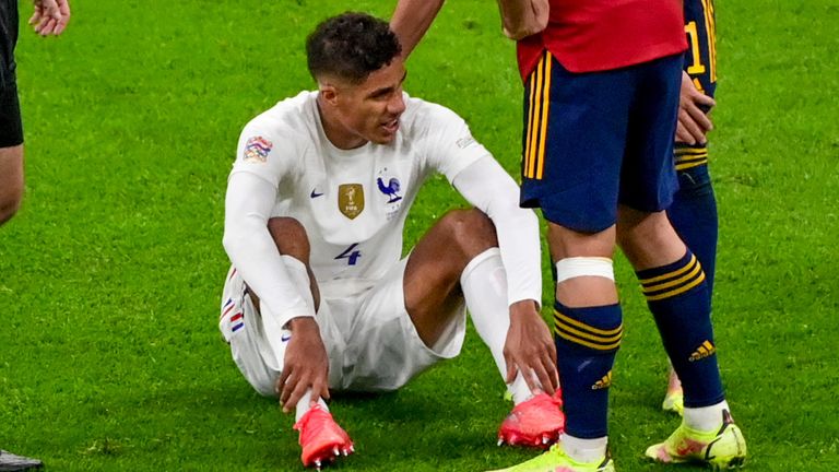 Raphael Varane sits on the pitch after an injury during the Nations League final - Miguel Medina/Pool Photo via AP