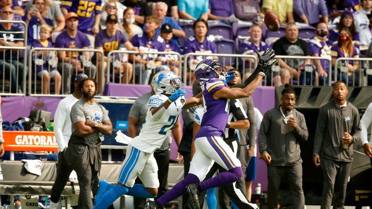 Minnesota Vikings wide receiver Justin Jefferson (18) catches a pass ahead of Detroit Lions cornerback Amani Oruwariye (24) during the first half of an NFL football game, Sunday, Oct. 10, 2021, in Minneapolis.