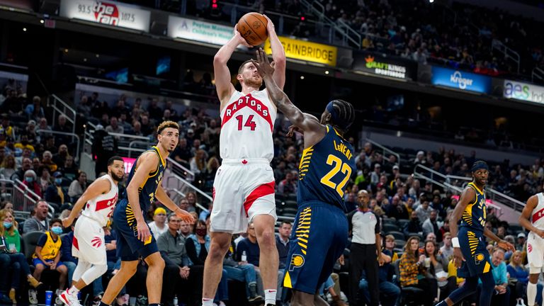 Toronto Raptors guard Svi Mykhailiuk (14) shoots over Indiana Pacers guard Caris LeVert (22) during the first half of an NBA basketball game in Indianapolis, Saturday, Oct. 30, 2021. (AP Photo/Michael Conroy)



