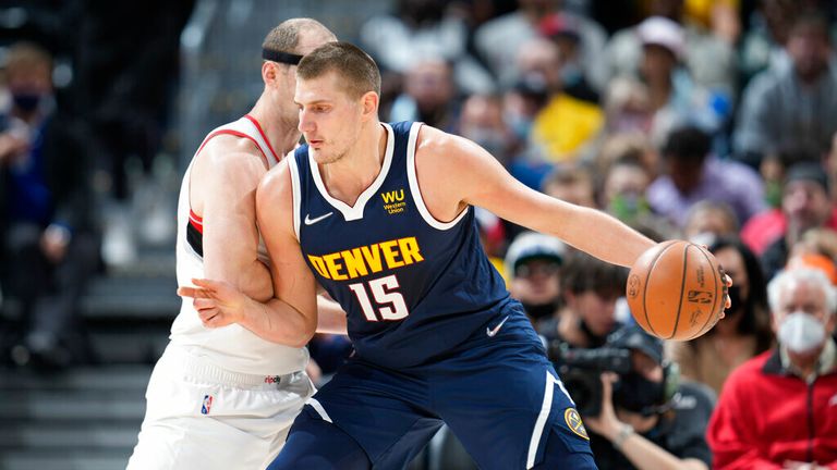 Denver Nuggets center Nikola Jokic, front, drives past Portland Trail Blazers center Cody Zeller in the first half of an NBA basketball game Sunday, Nov. 14, 2021, in Denver. (AP Photo/David Zalubowski)