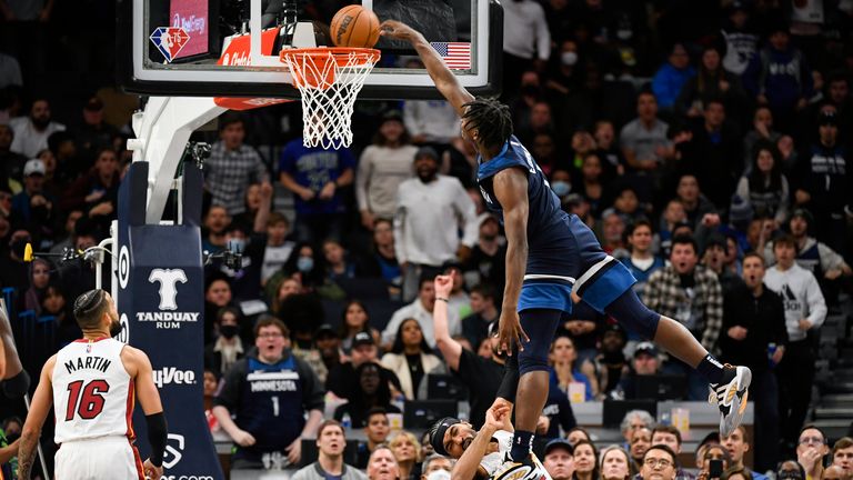 Minnesota Timberwolves guard Anthony Edwards is called for an offensive foul as he leaps over Miami Heat guard Gabe Vincent and dunks the ball