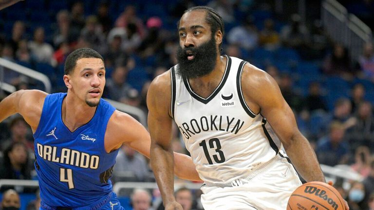 Brooklyn Nets guard James Harden (13) drives to the basket in front of Orlando Magic guard Jalen Suggs (4) during the first half of an NBA basketball game Wednesday, Nov. 10, 2021, in Orlando, Fla. (AP Photo/Phelan M. Ebenhack)