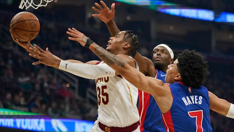 Cleveland Cavaliers&#39; Isaac Okoro drives to the basket against Detroit Pistons&#39; Jerami Grant and Killian Hayes