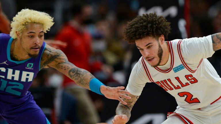 Chicago Bulls guard Lonzo Ball (2) battles Charlotte Hornets guard Kelly Oubre Jr. (12) for the ball during the second half of an NBA basketball game Monday, Nov. 29, 2021, in Chicago. (AP Photo/Paul Beaty)