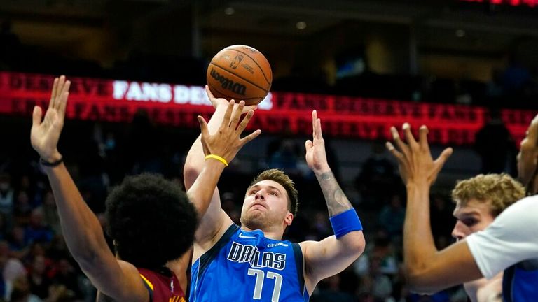 Cleveland Cavaliers center Jarrett Allen, left, defends against a shot by Dallas Mavericks guard Luka Doncic (77) in the first half of an NBA basketball game in Dallas, Monday, Nov. 29, 2021. (AP Photo/Tony Gutierrez)