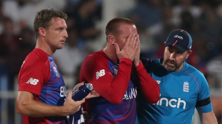 England's Jos Buttler (L) looks on as opening partner Jason Roy is helped off the field after pulling up during the T20 World Cup match against South Africa (Associated Press)