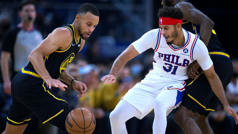 Golden State Warriors guard Stephen Curry attempts to drive past Philadelphia 76ers guard Seth Curry