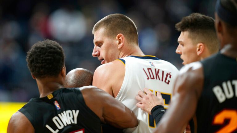 Denver Nuggets center Nikola Jokic, center, is restrained by Miami Heat guards Kyle Lowry, left, and Tyler Herro after knocking over Heat forward Markieff Morris during a scrum in the second half of an NBA basketball game Monday, Nov. 8, 2021, in Denver. Jokic was ejected, Morris assessed a personal foul for his part in the altercation. (AP Photo/David Zalubowski)