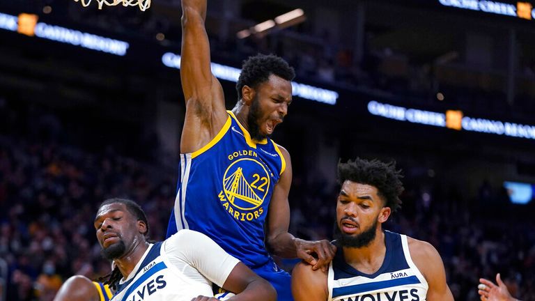 Golden State Warriors forward Andrew Wiggins (22) reacts after dunking against Minnesota Timberwolves' Naz Reid (11) and Karl-Anthony Towns (32) during the second half of an NBA basketball game in San Francisco, Wednesday, Nov. 10, 2021. (AP Photo/Jeff Chiu)
