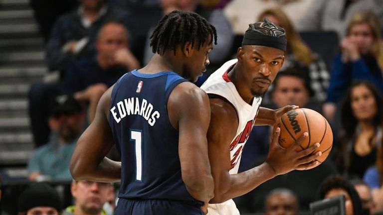 Miami Heat forward Jimmy Butler looks to pass the ball around Minnesota Timberwolves guard Anthony Edwards