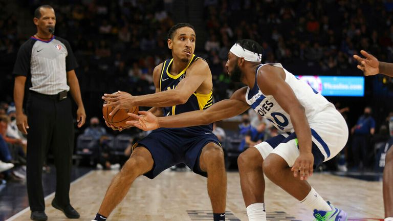 Indiana Pacers guard Malcolm Brogdon (7) handles the ball against Minnesota Timberwolves forward Josh Okogie (20) during the second half of an NBA basketball game Monday, Nov. 29, 2021, in Minneapolis. Minnesota won 100-98. (AP Photo/Stacy Bengs)