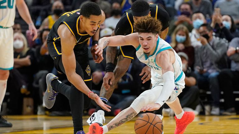 Golden State Warriors guard Jordan Poole reaches for the ball in front of Charlotte Hornets guard LaMelo Ball 