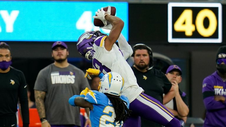 Minnesota Vikings wide receiver Justin Jefferson (18) catches a pass while defended by Los Angeles Chargers defensive back Tevaughn Campbell 