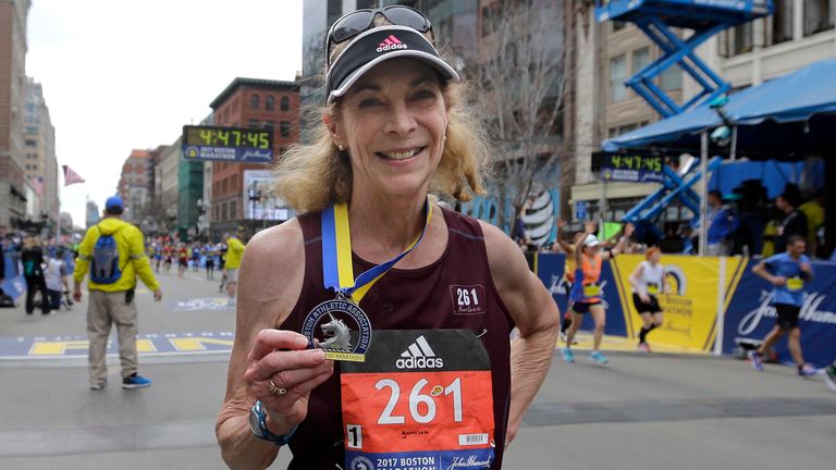 Kathrine Switzer, who was the first official woman entrant in the Boston Marathon 50 years ago, wears the same bib number and displays her medal after finishing the 121st Boston Marathon on Monday, April 17, 2017, in Boston
