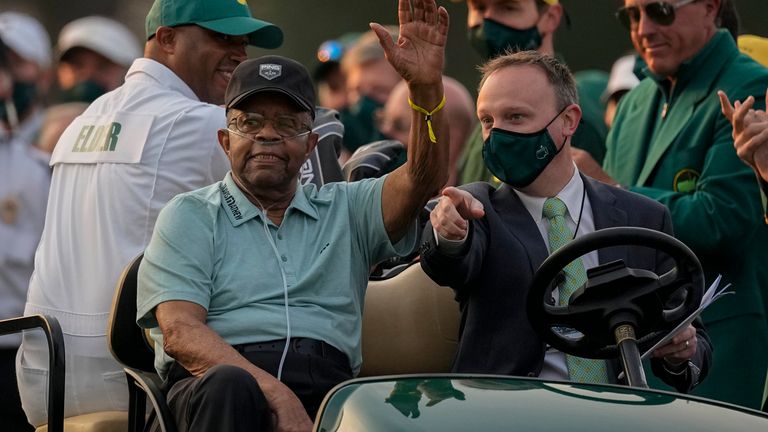 Lee Elder waves as he arrives for the ceremonial tee shots before the first round of the Masters golf tournament in 2021
