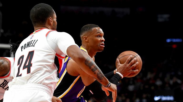 Los Angeles Lakers guard Russell Westbrook, right, drives to the basket on Portland Trail Blazers forward Norman Powell, left, during the first half of an NBA basketball game in Portland, Ore., Saturday, Nov. 6, 2021. (AP Photo/Steve Dykes)