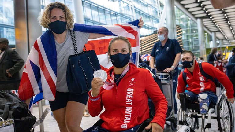 LONDON, ENGLAND - SEPTEMBER 05: Lucy Shuker (centre), who won Silver in the Women's Doubles Wheelchair Tennis at the Tokyo 2020 Paralympics, is greeted by family and friends at Heathrow on September 05, 2021 in London, England. Team GB ranked second in the medal count for the Tokyo 2020 Paralympics, behind China. (Photo by Rob Pinney/Getty Images)