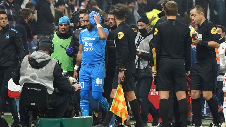 Marseille's Dimitri Payet (C) is surrounded by his staff as he leaves the field after being injured by a bottle thrown from the stands